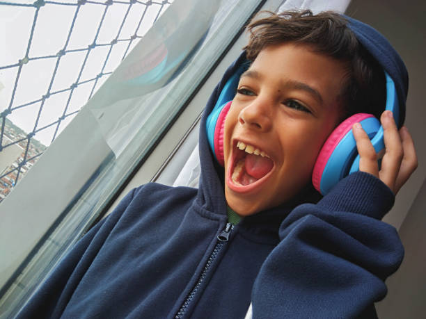 Boy with headphones, looking out the window