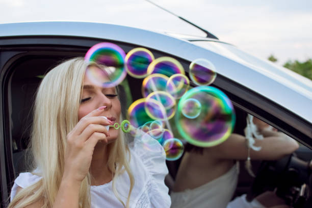 istock Woman blowing bubbles on road trip 1010313846