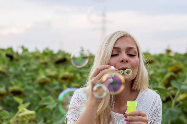 istock Young woman blowing soap bubbles 1010313878