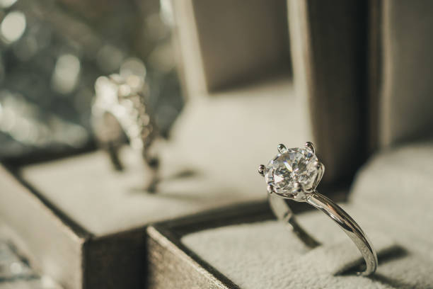 istock luxury engagement Diamond ring in jewelry gift box with bokeh light background 1010329422
