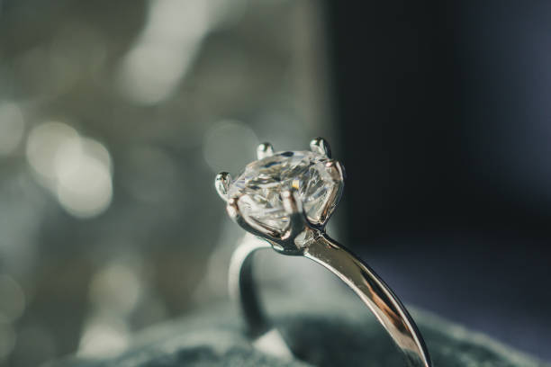 istock luxury engagement Diamond ring in jewelry gift box with bokeh light background 1010329426