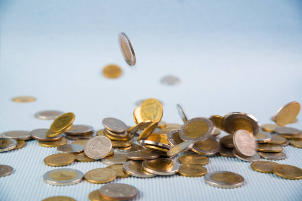 istock Falling coins money on blue background, business wealth concept. 1010329610