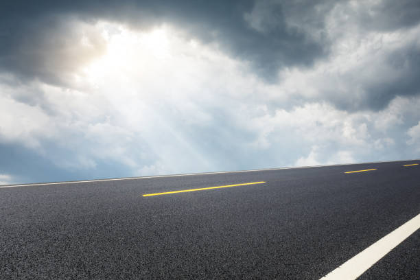 istock Asphalt road and sky black clouds 1010329880