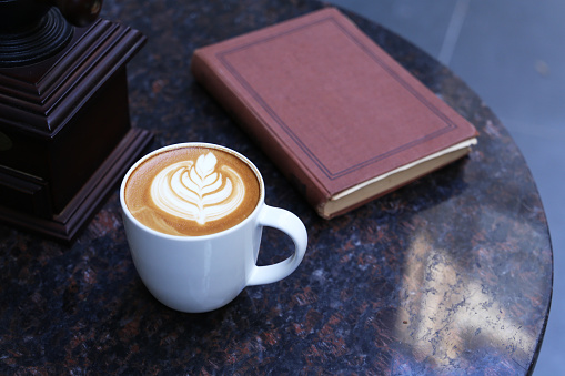 coffee latte on marble table and book
