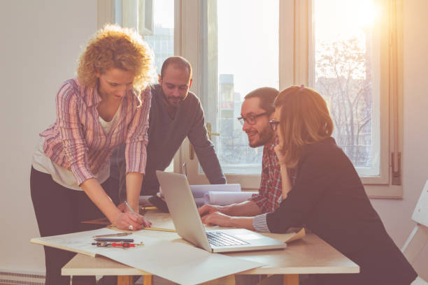 istock Group of young architects in the sunny office. 1010357408