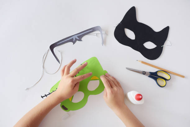 att göra masker papper holiday halloween monster's mask svart katt händer ovanifrån - school animal coloring bildbanksfoton och bilder