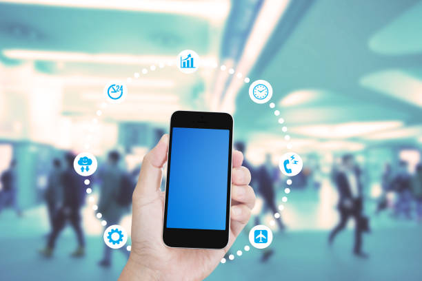 Hand holding mobile phone with blurred image of people use for background
