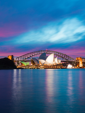 Sydney, Australia - June 29, 2018: Dusk view of Sydney Opera House in front of Sydney Harbour Bridge.