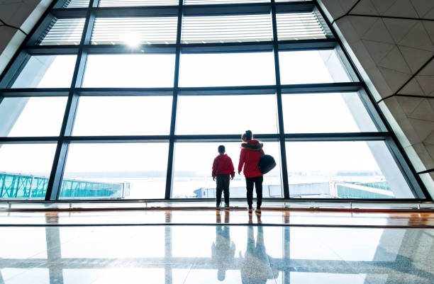 istock Mother and son looking through the window at airport 1010413222