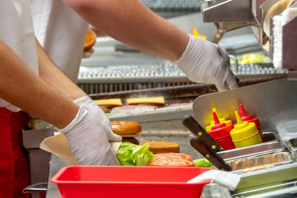 trabalhadores de fast-food, trabalhando em um restaurante de hambúrguer - restaurante de fast food - fotografias e filmes do acervo