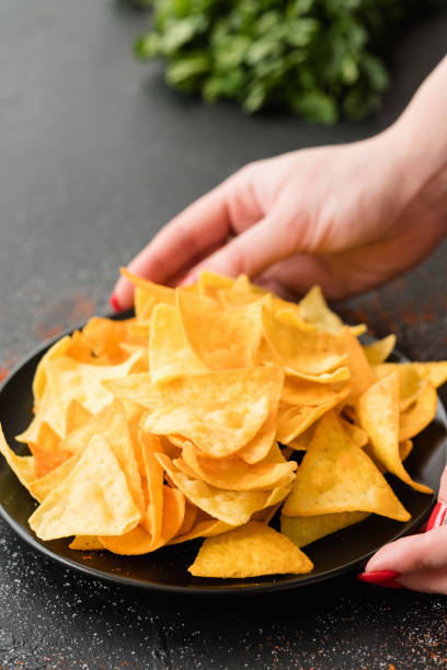 istock homemade fried nacho chips food hand offer plate 1010416300