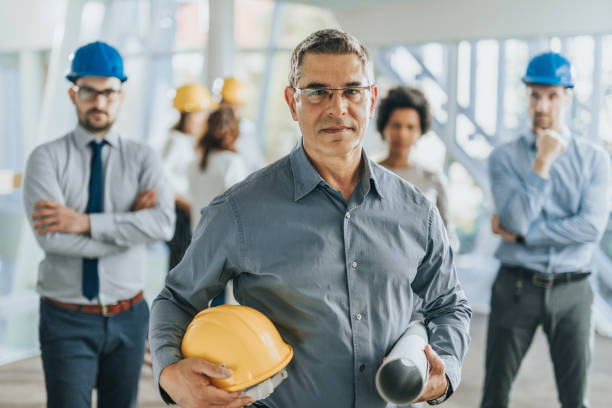 istock Confident architect in front of his team in a hallway. 1010440326