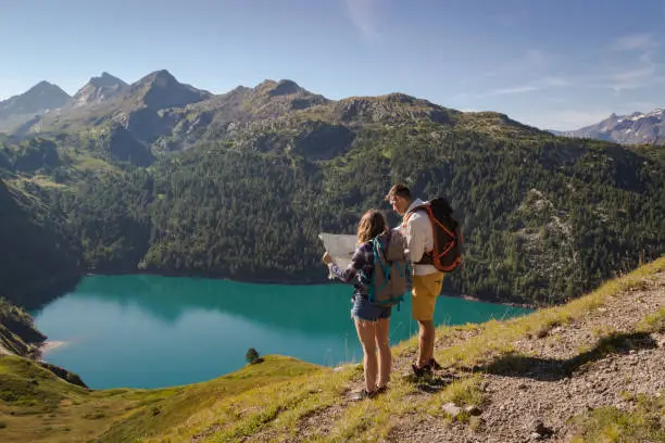 Couple reading map in front a lake swiss alps