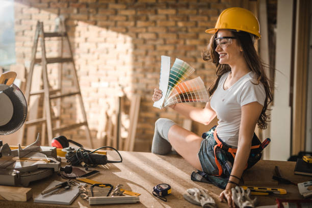 istock Young cheerful female worker having fun with color swatch at construction site. 1010443064