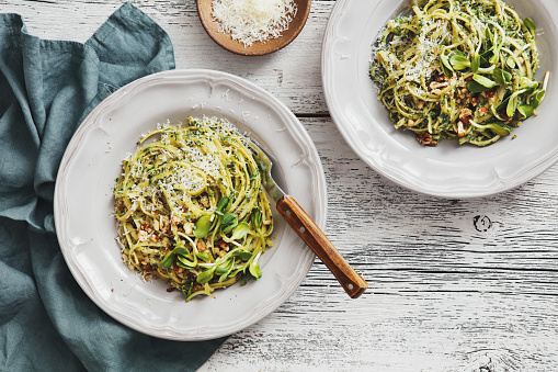 Spaghetti with vegetables, spinach, nuts and parmesan