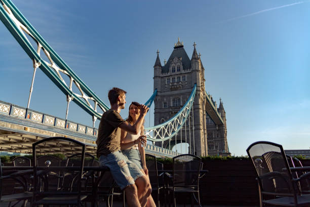 пара наслаждаться закатом следующий мост башни - tower bridge london england panoramic bridge стоковые фото и изображения