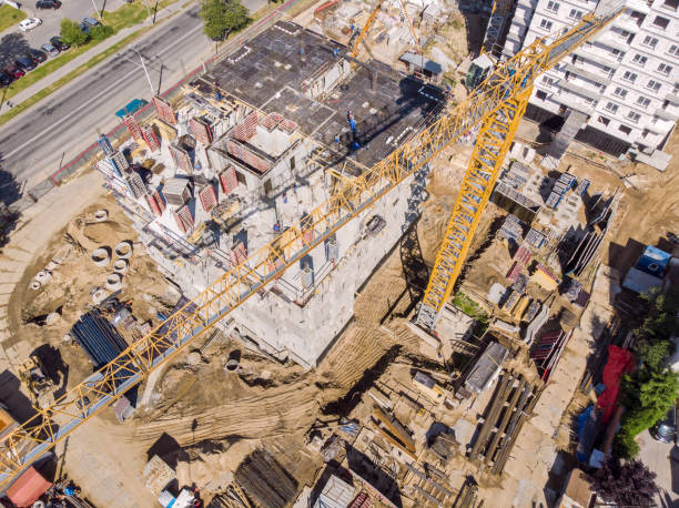 istock yellow tower crane at construction site. aerial top view 1010466982