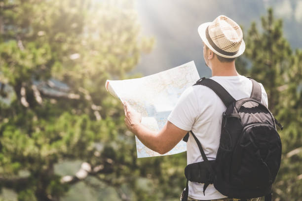 istock Backpacker with the map on the top of the mountain 1010477358