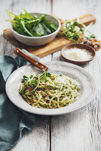 Spaghetti with vegetables, spinach, nuts and parmesan
