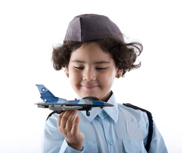 Little Indian girl in air force costume holding toy fighter jet
