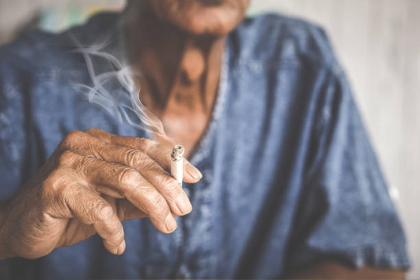 азиатский мужчина стороны проведения курения сигарет - курение стоковые фото и изображения