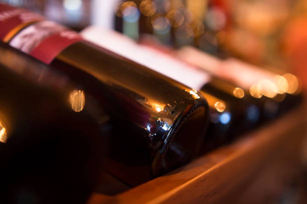 bottiglie di vino di fila in un negozio di vini da vicino - bottling plant winery wine industry foto e immagini stock