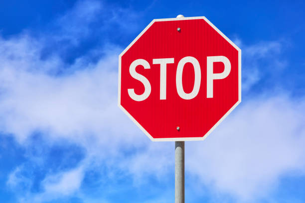 istock Red stop sign against blue cloudy sky background. Traffic regulatory warning sign. 1010501144