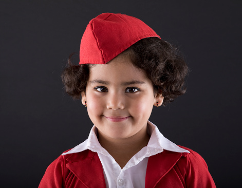 Little girl with arms crossed dressed up as air stewardess