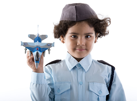 Little Indian girl in air force costume holding toy fighter jet