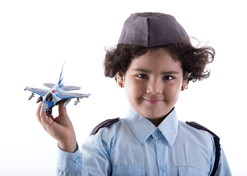 Little Indian girl in air force costume holding toy fighter jet