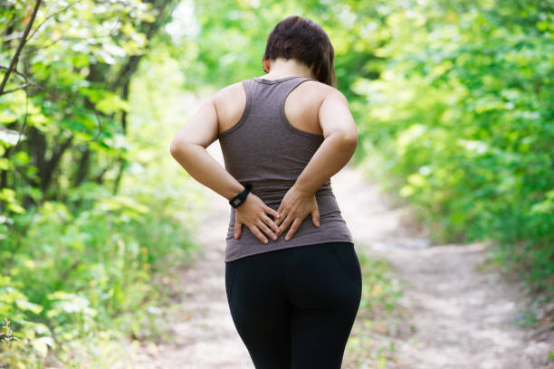 женщина с болью в спине, воспаление почек, травмы во время тренировки - human spine human age horizontal outdoors стоковые фото и изображения