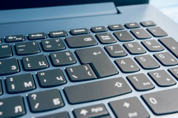 istock Gradient Blue Brand New Laptop With Balck Keyboard Closeup On Blue Wood Surface 1010510542