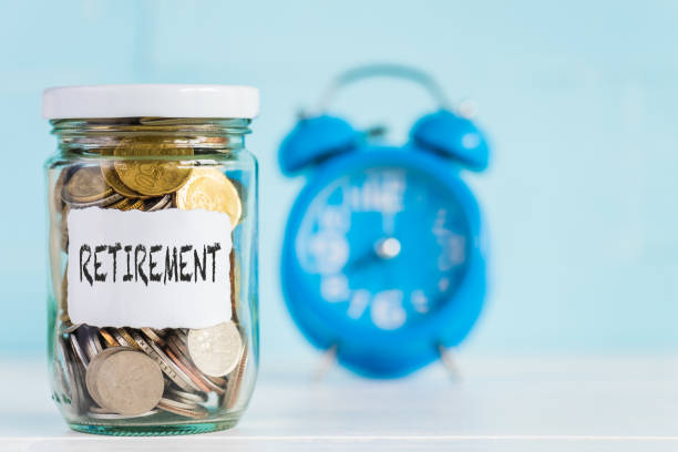 istock Glass jar coins with alarm clock background for retirement concept. 1010510554
