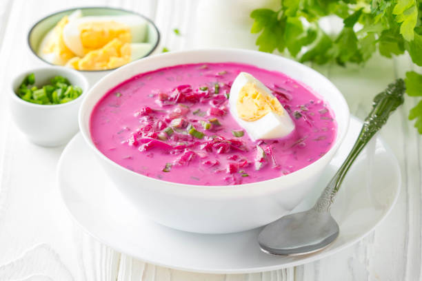 Cold borsch, summer beet soup with fresh cucumber, radish and boiled egg in white bowl. Traditional European food, delicious lunch stock photo