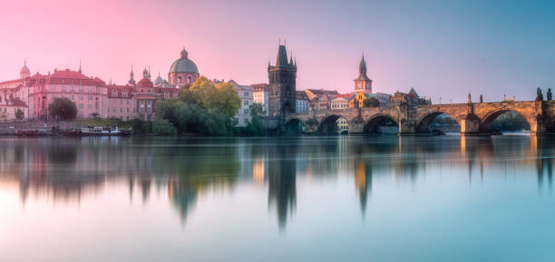 Morning view of Charles bridge and Prague cityscape with sunbeams, Czech Republic. Travel concept background.