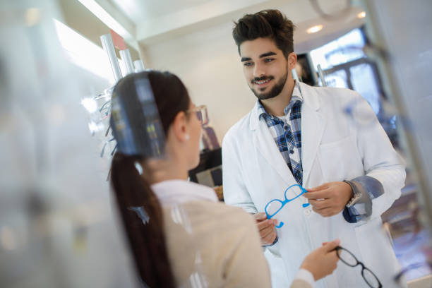 istock Selecting eyeglasses in optical store with assistance of optometrist 1010511094