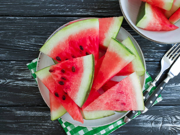 istock ripe watermelon piece, plate on a black wooden background 1010522648