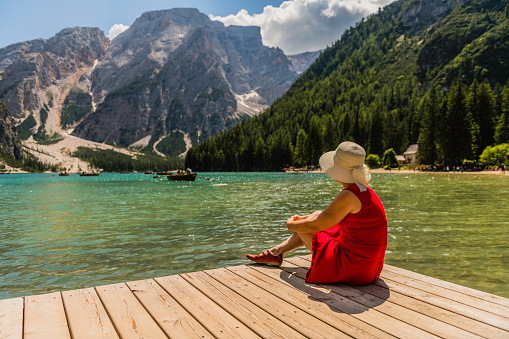 Mature woman enjoys summer on the coast of Braies Lake, Dolomites, European Alps, Italy, Europe,Nikon D850