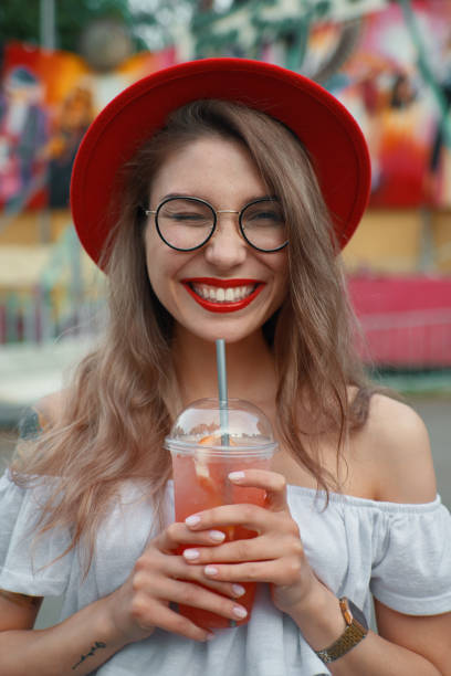 istock Cheerful young woman holding a drink while smiling 1010540210