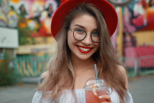 istock Cheerful young woman holding a drink while smiling 1010540330