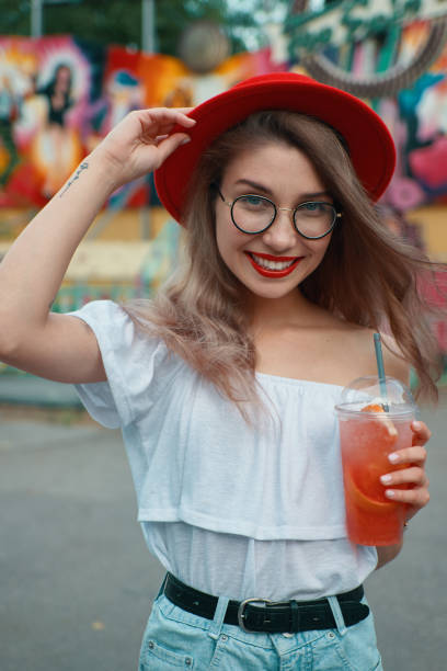 istock Cheerful young woman holding a drink while smiling 1010542622