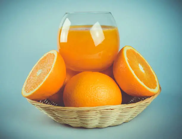 Fresh orange juice on top the oranges basket. dark background. health lover. Refreshing summer. is suitable for social networking. magazine.