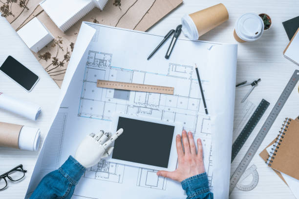 istock cropped image of male architect with prosthetic arm using digital tablet over blueprint at table 1010555070