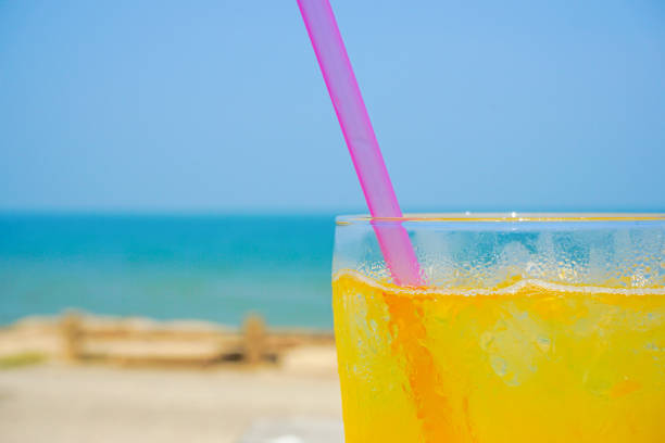 istock Orange juice drinking on the beach. 1010555256