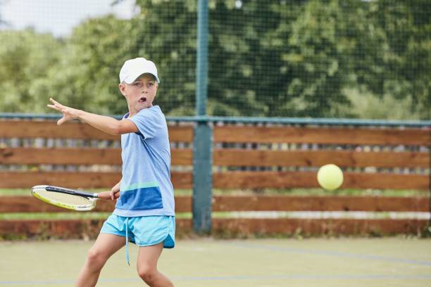 kleiner junge tennis spielen - forehand stock-fotos und bilder