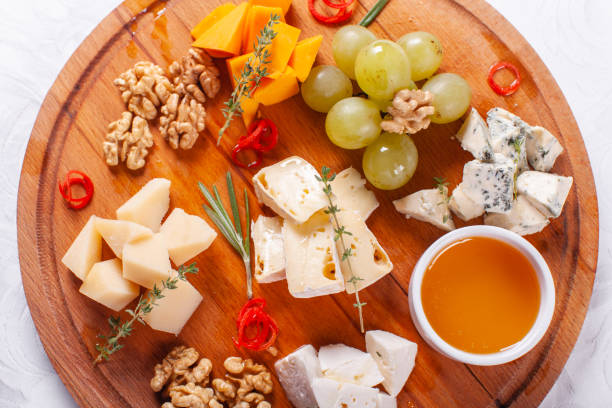 istock Cheese plate. Delicious cheese mix with walnuts, honey, grapes on wooden table. Tasting dish on a wooden plate. Food for wine. 1010560792