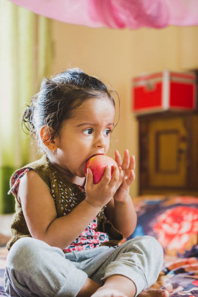 istock Cute Happy Child Eating Red Apple 1010568676