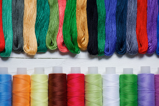 Close - up of coils of threads of different colors and shades for sewing, embroidery and creativity. The view from the top. The concept of Hobbies and crafts.