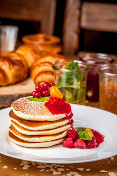 istock A stack of American pan cakes with jam and forest berries, in the restaurant for breakfast. in the background, jam with croissants. Copy space, selective focus 1010575790