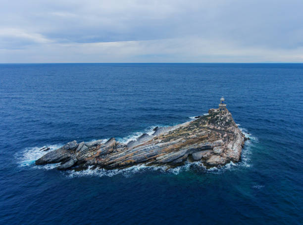 istock Layered rocky island with a lighthouse 1010576358